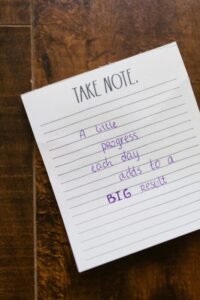 Motivational note on paper with handwritten text on a wooden table.