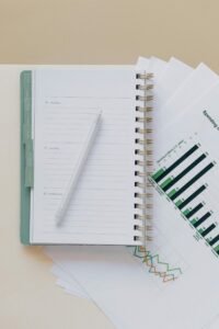 An open planner with a pen on top of graph sheets, perfect for planning and organization.