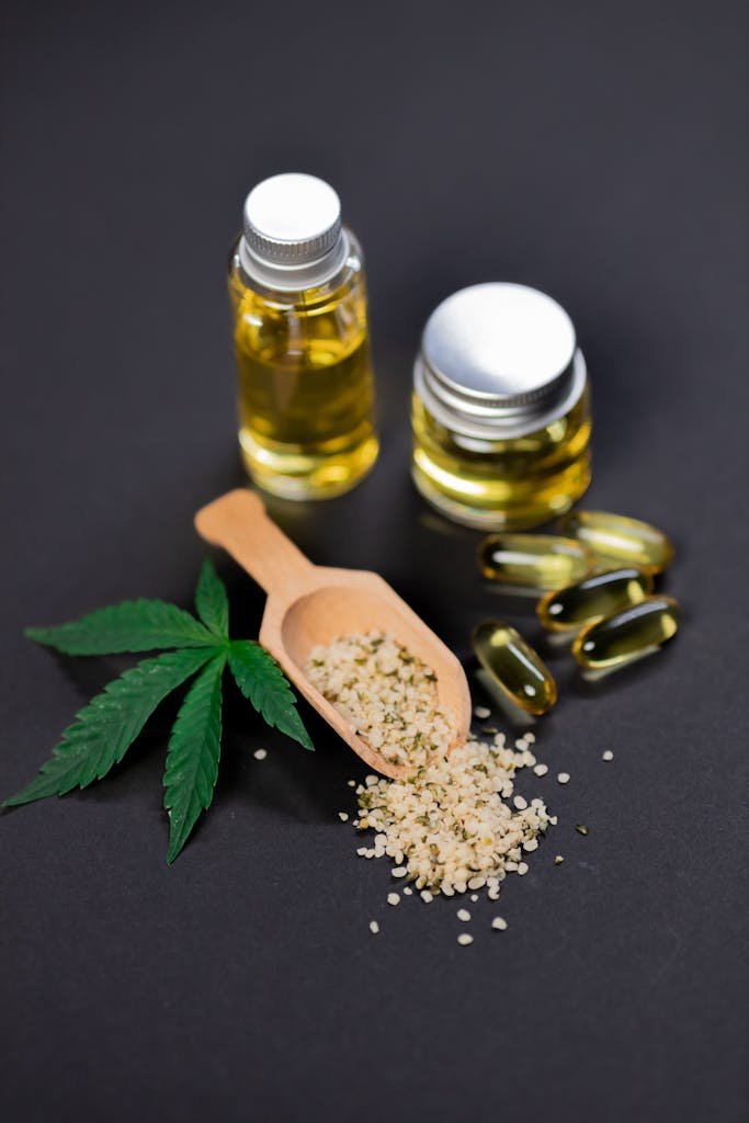 🌿 What Is CBD & How Does It Work? 1 Flat lay of cannabis oil, hemp seeds, capsules, and leaf on dark background.